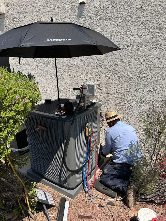 HVAC technician performing outdoor AC maintenance in Tonawanda